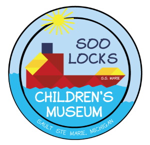 The Soo Locks Children's Museum logo comprised of a circle with a red freighter in blue water and yellow sun in a light blue sky.